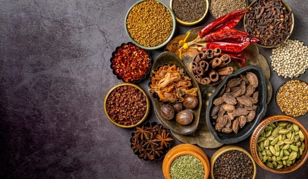 A top view of various Indian spices and seasonings on a table